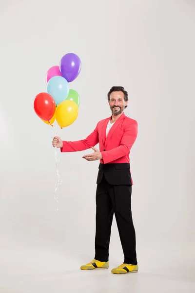 Homme en veste rouge avec des ballons colorés — Photo