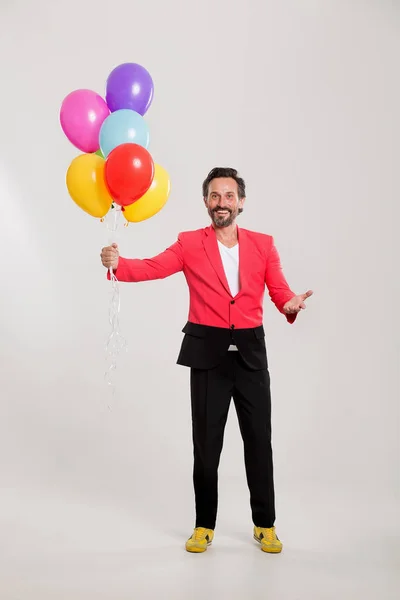 Homem de casaco vermelho com balões coloridos — Fotografia de Stock