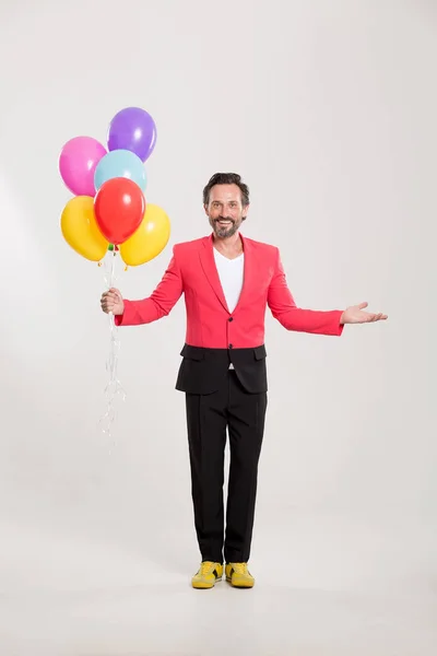 Mannen i röd jacka med färgglada ballonger — Stockfoto
