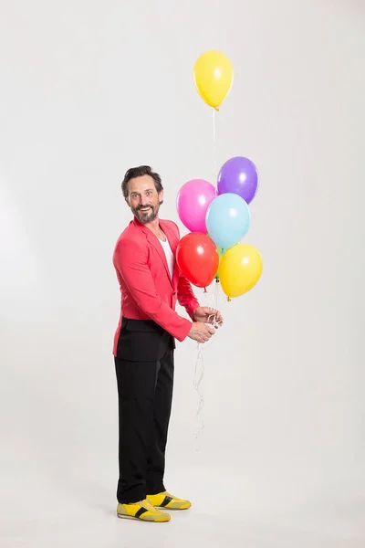 Homme en veste rouge avec des ballons colorés — Photo