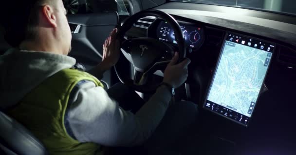 Man zit op stuurwiel van Tesla auto — Stockvideo