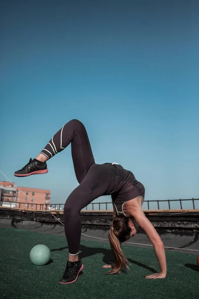Menina desportiva no telhado realizando arte ginástica . — Fotografia de Stock