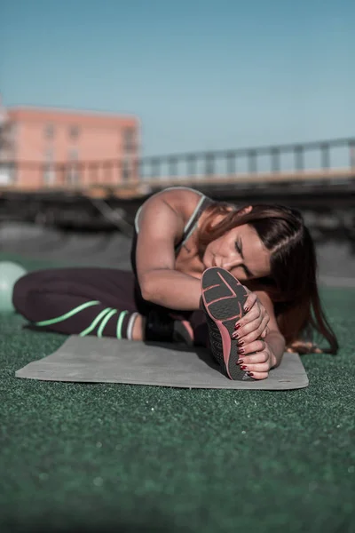 Aantrekkelijke sportieve vrouw stretching na training. — Stockfoto