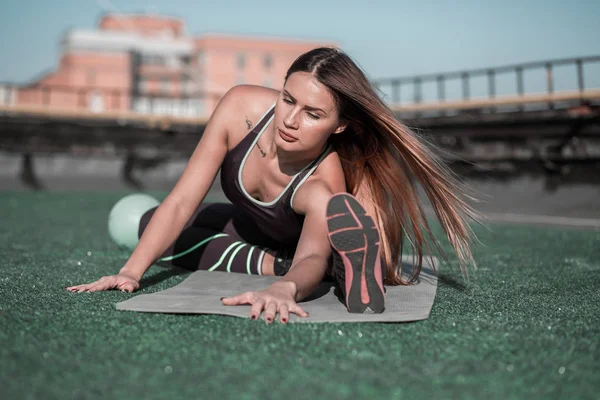 Fitness op het dak, sportieve vrouw die zich uitstrekt. — Stockfoto