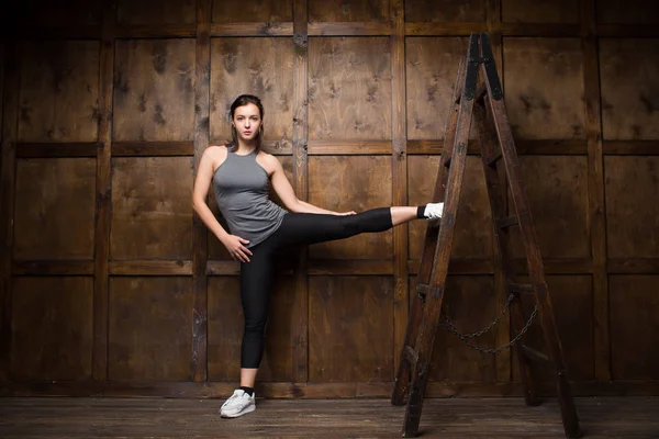 Donna forte con una scala in legno — Foto Stock