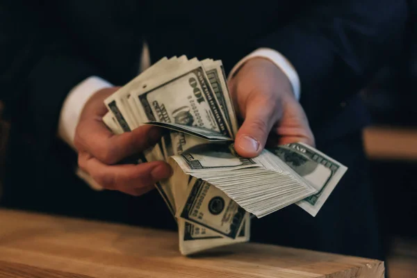 Stacks of one hundred dollars banknotes on wooden desk — Stock Photo, Image