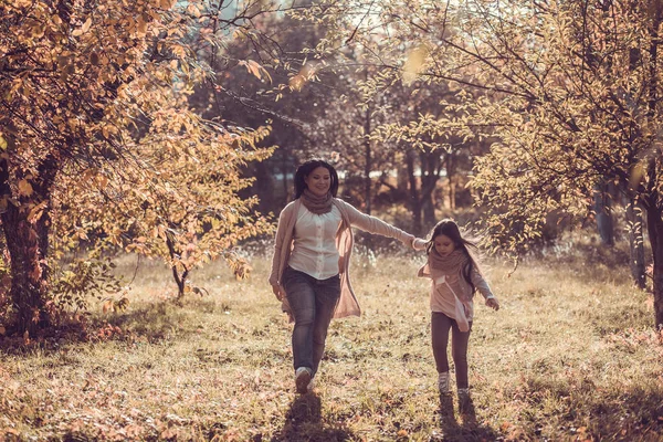 Gelukkig moeder en de dochter spelen herfst park — Stockfoto