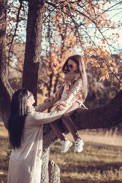 美しい若い女性と彼女の子供秋の庭の — ストック写真