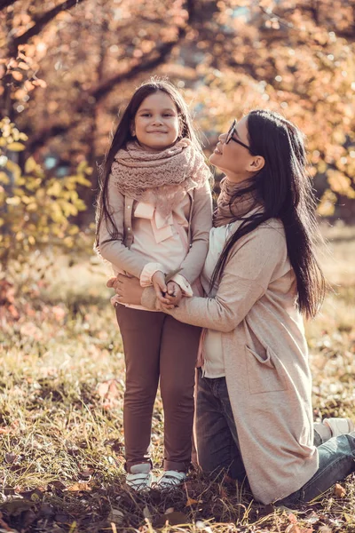 Hermosa joven y su hijo en el jardín de otoño — Foto de Stock