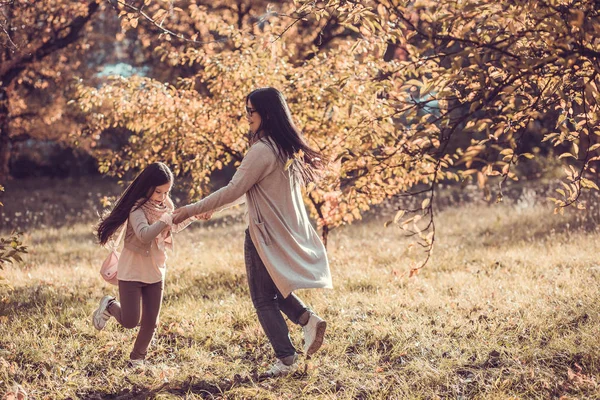 Hermosa joven y su hijo en el jardín de otoño — Foto de Stock