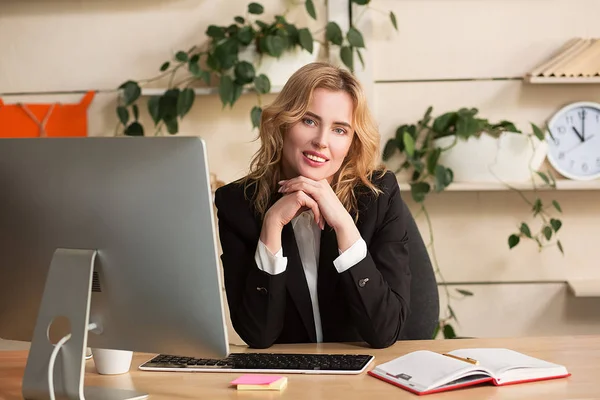 Young woman working in office, sitting at desk