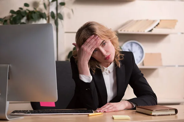 Jeune femme au bureau, assise au bureau — Photo