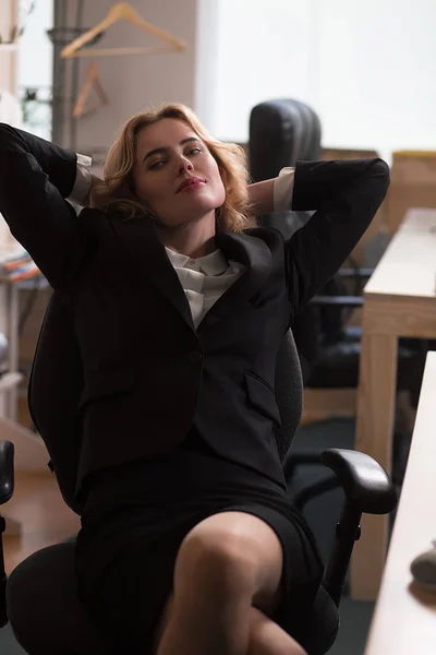 Junge schöne Geschäftsfrau entspannt sich im Büro. — Stockfoto