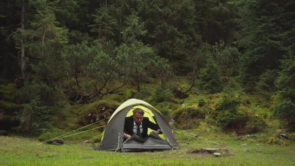 Человек в черном костюме выходит из палатки и готов начать свой рабочий день — стоковое видео