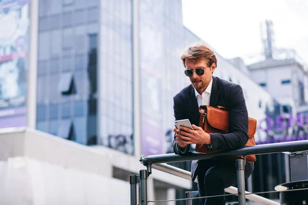 Mladý a pohledný podnikatel pracuje na cestách na svém telefonu — Stock fotografie