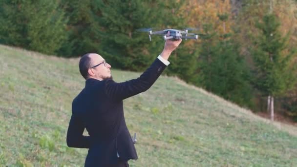 Muž s brýlemi drží svého drona svýma rukama — Stock video