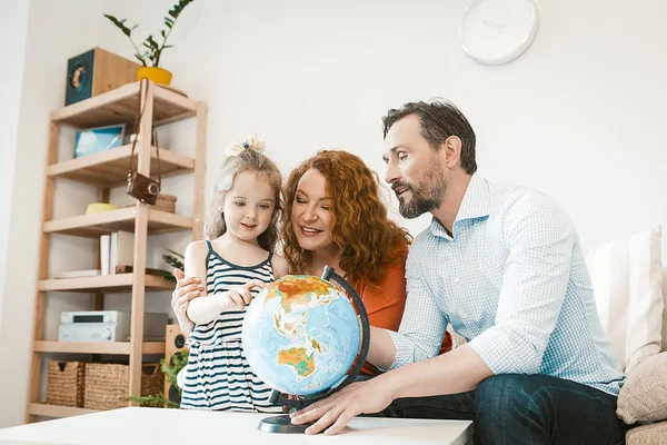 Planerar semester, föräldrar och liten dotter studerar världen. — Stockfoto