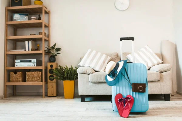 Resväska med hatt och tofflor i vardagsrummet. — Stockfoto