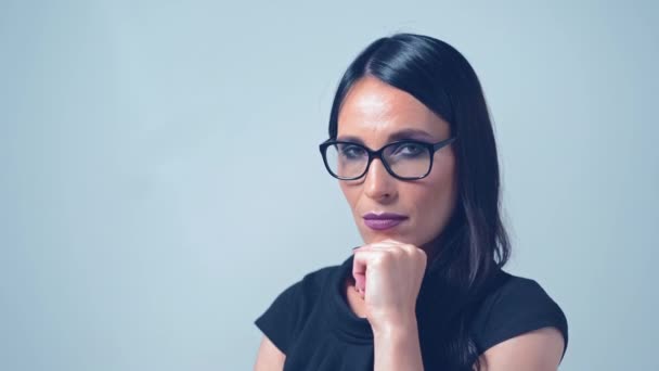 Encantadora mujer en un elegante vestido negro con gafas está mirando a la cámara y asintiendo con la cabeza — Vídeos de Stock