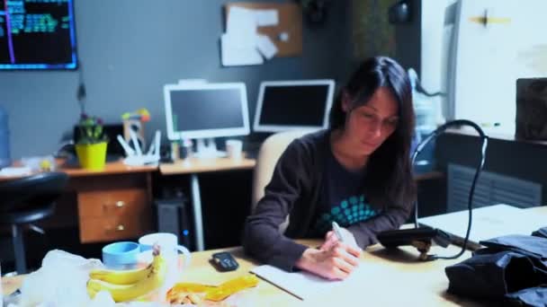 Occupé femme d'âge moyen est assis à la table de bureau tenant un stylo dans sa main — Video