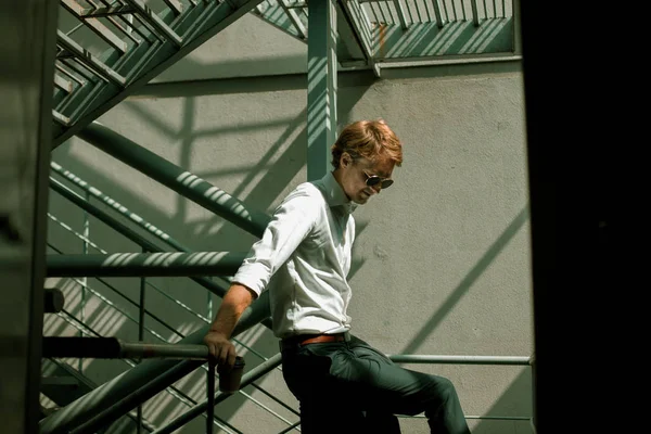 El joven hombre de negocios con gafas de sol apoyado en el barandilla — Foto de Stock