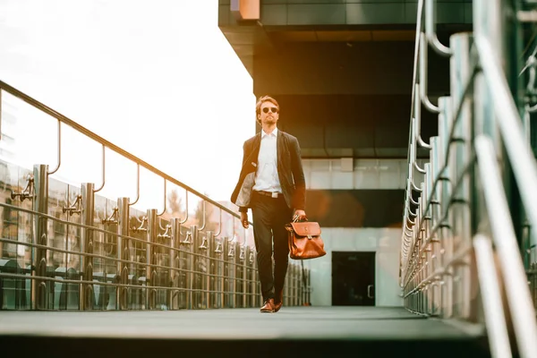 El hombre caminando en el puente del centro de negocios y mirando a su alrededor — Foto de Stock