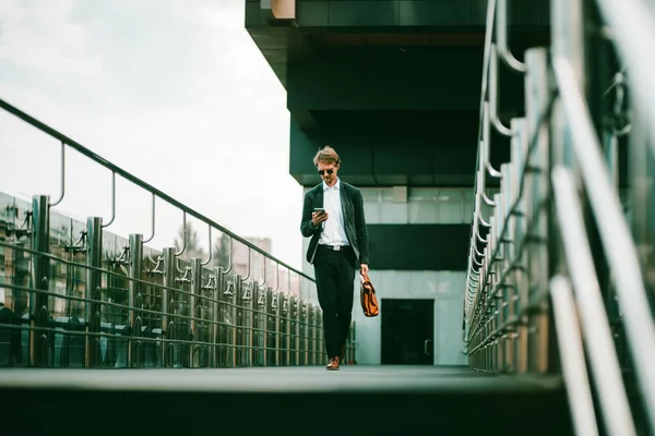 El hombre de negocios caminando en el puente del centro de negocios — Foto de Stock