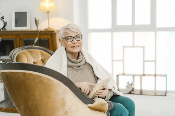 Elderly Lady Sitting On The Leather Sofa And Holding A Tablet — Stock Photo, Image