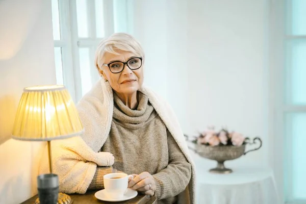 Velha Relaxante em casa e bebendo chá — Fotografia de Stock