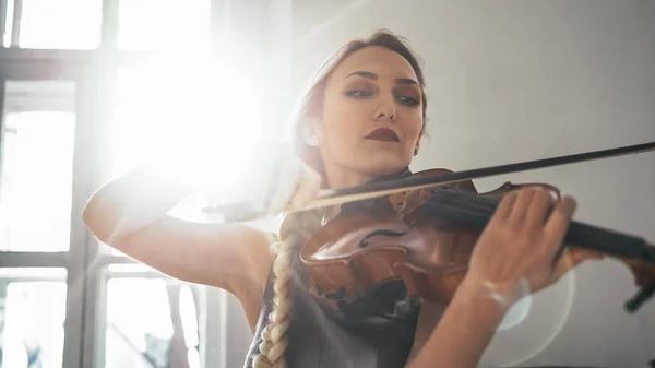 Fiatal vonzó nő egy gyönyörű ruha játszik a hegedűn — Stock Fotó