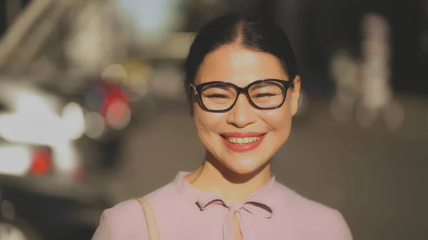Una donna d'affari di mezza età bruna con gli occhiali che ride felicemente nella giornata di sole — Foto Stock
