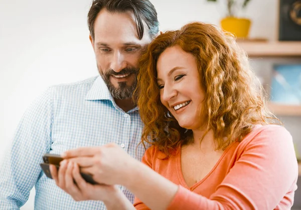 Familjepar tittar på mobiltelefon. — Stockfoto