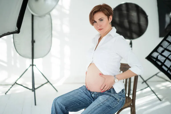 Těhotná žena představuje v profesionálním fotografickém studiu — Stock fotografie