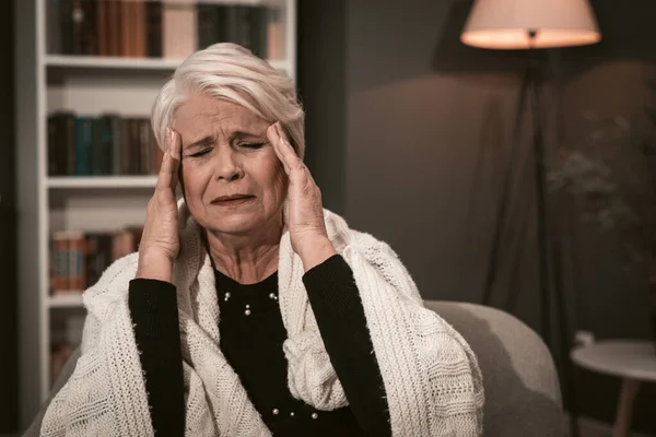 Dame âgée massages ses temples avec ses mains — Photo