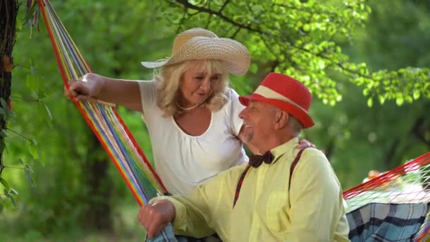 Charmantes älteres Paar ruht sich im Sommergarten aus — Stockvideo