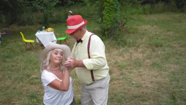 Die alte Dame und der Gentleman tanzen im Garten — Stockvideo