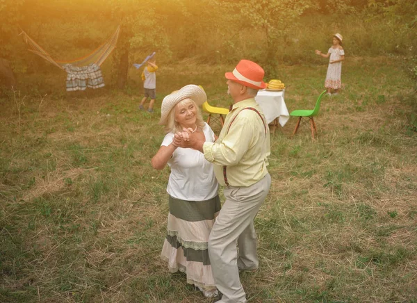 De oude dame en de heer dansen in de tuin — Stockfoto