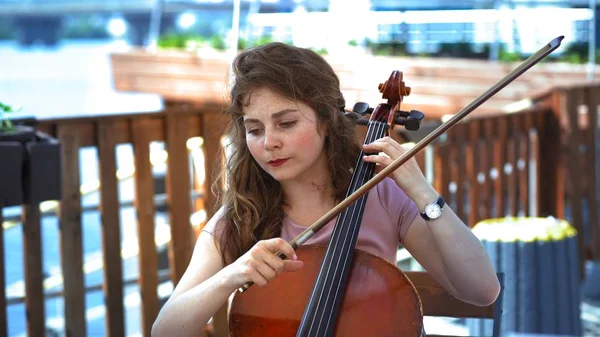 Musicista femminile suona il violoncello sulla terrazza estiva all'aperto — Foto Stock