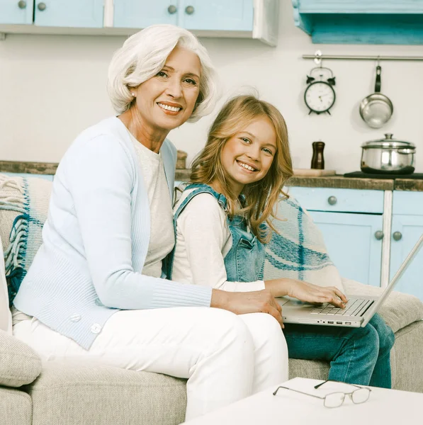 Grootmoeder blij om haar kleindochter te helpen met laptop — Stockfoto