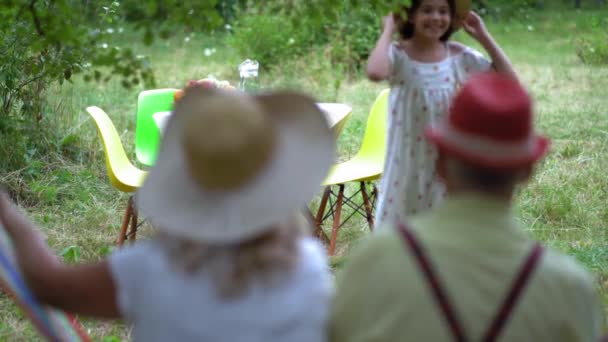 Het oude stel zit in de hangmat in de tuin. — Stockvideo