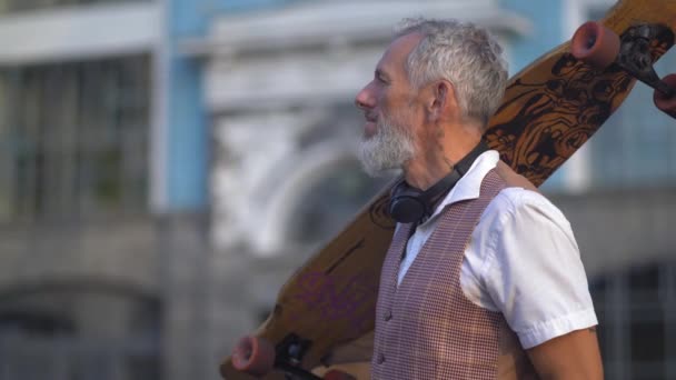 Patinador de mediana edad admira la arquitectura urbana borrosa Volver — Vídeo de stock