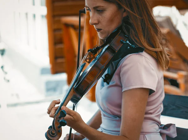Скрипачка, играющая классическую музыку на летней террасе — стоковое фото