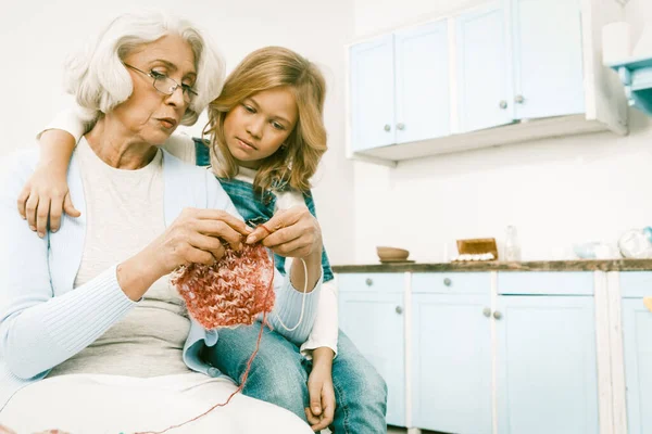 White Haired Grandmother Show Granddaughter How To Knit A Scarf Or Sweater