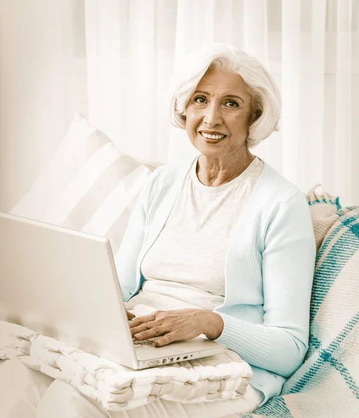 Bonne grand-mère en utilisant les technologies informatiques dans l'ordinateur portable — Photo
