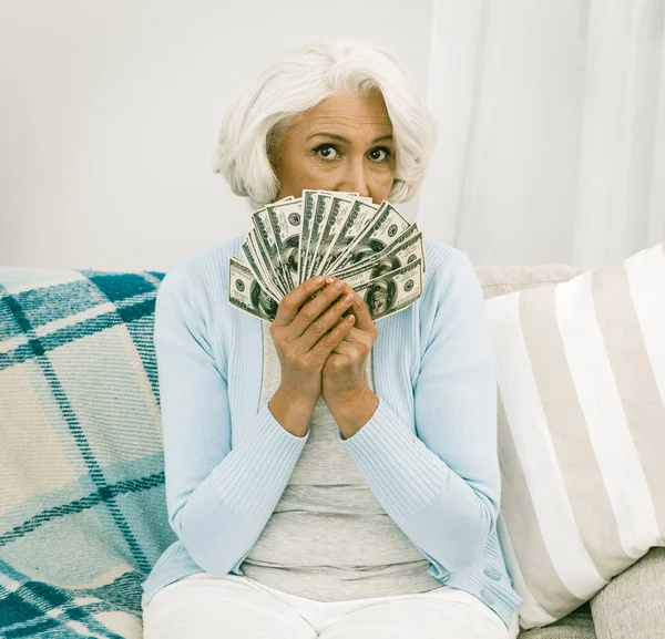 Senior Lady couvert son visage avec un ventilateur de billets de dollar — Photo
