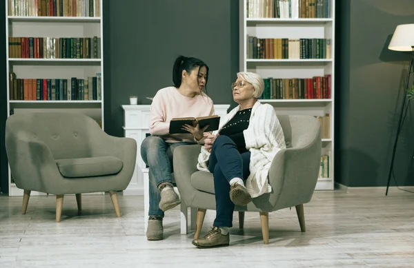 Adult Daughter Reads Book For Her Old Mother — Stock Photo, Image