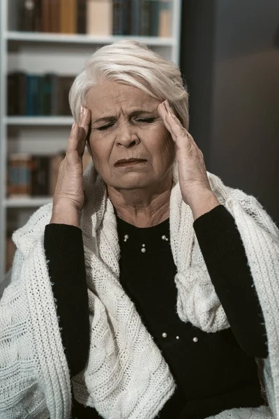 Expresiva anciana rubia siente un dolor de cabeza de estrés —  Fotos de Stock