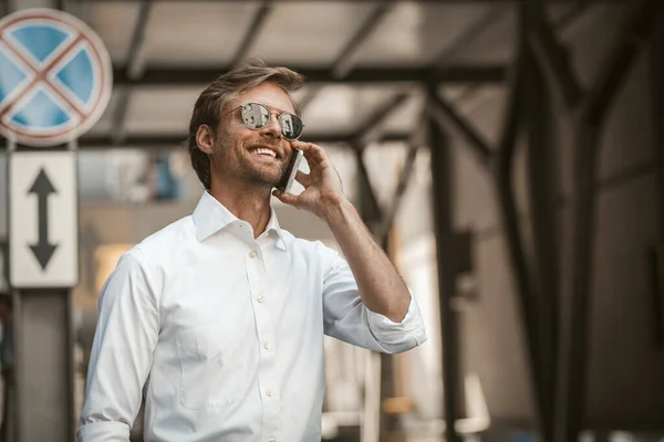 Handsome man talking on the telephone outdoors with urban background — 스톡 사진