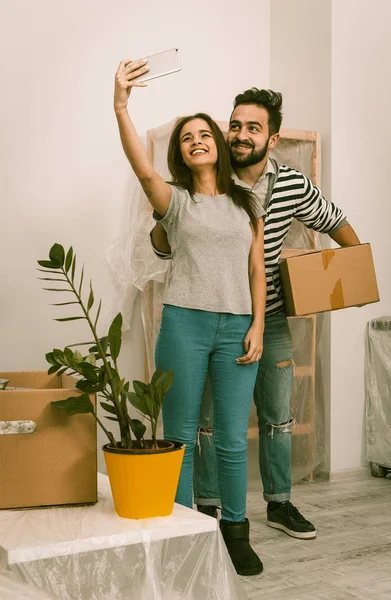 Man och kvinna i casual kläder står i nya hem efter flyttningen, vidarebefordran till nytt liv. — Stockfoto