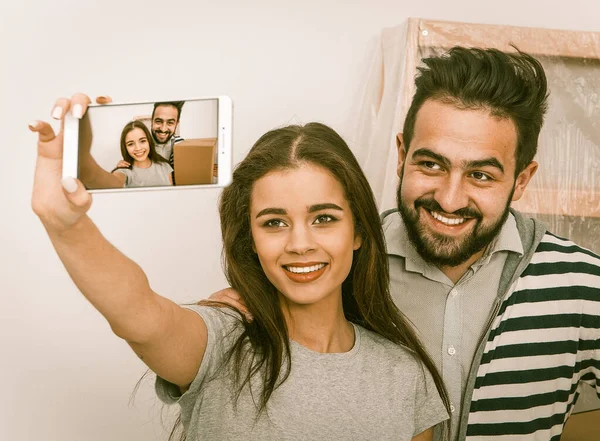 Переселення молодої щасливої пари робить селфі знімок у своїй новій квартирі . — стокове фото
